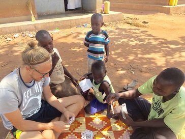 A Peace Corps Volunteer plays with children in Uganda.