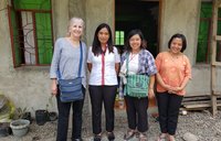 Four people standing in front of building and smiling