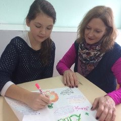 Sandra Dale Woodruff reviews a Thanksgiving poster with her student