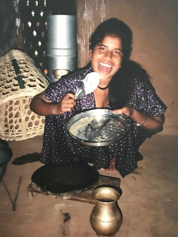 A young Nepali woman cooking in her home.