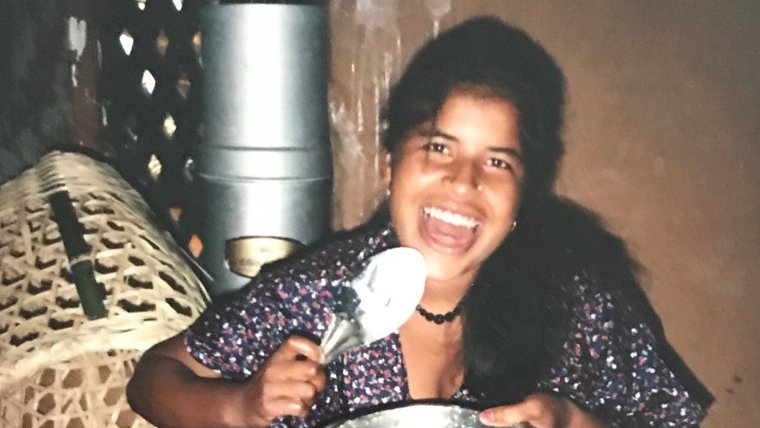 A young Nepali woman cooking in her home.