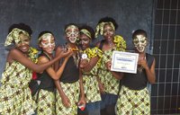 A school dance group shows off their award after a performance.