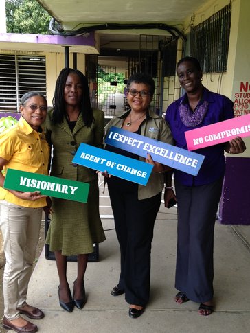 Five teachers standing with signs