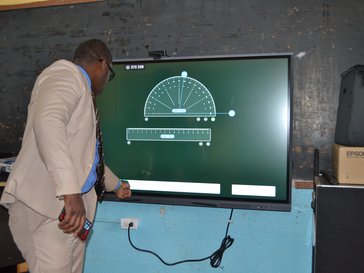 A man plays with the settings of a tv which has a digital projector on