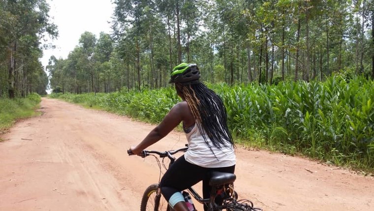 A woman on a bike on a rural road.