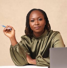 A headshot of a woman in front of a computer