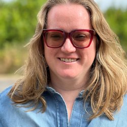 Woman wearing glasses and a blue button-up shirt