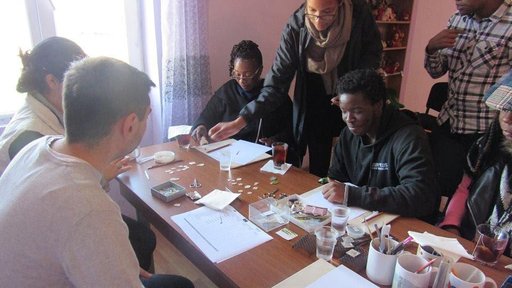 Some out-of-town visitors and Peace Corps Volunteers learn how to make enamel jewelry during a workshop.