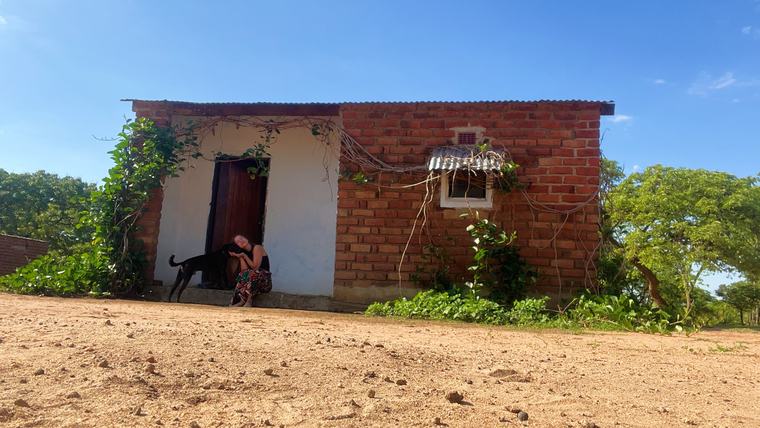Sophie and her dog Mtunzi ("shadow") in front of her home in Zambia’s Eastern Province.