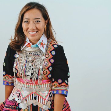 Volunteer is in her traditional clothing of the Hmong people.