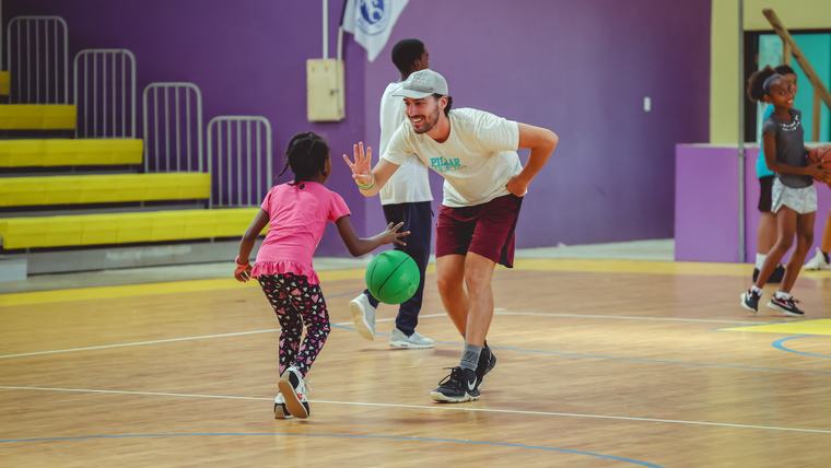 A student receives tips for good basketball form.