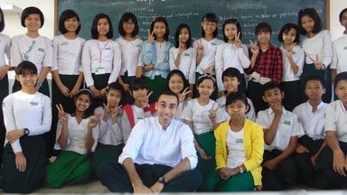 Peace Corps Volunteer Joel Bosque poses for a group photo with over 20 students who participated in his TOEFL prep course.