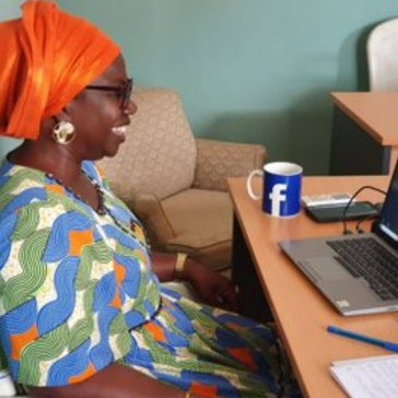 A Beninese woman joins a virtual meeting.
