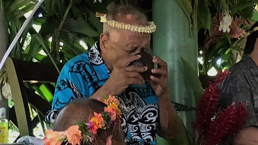 Taking sakau from a traditional half coconut shell