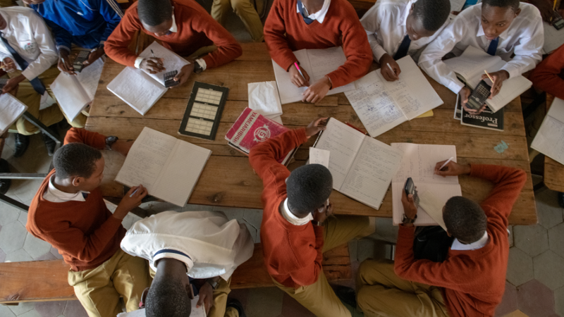 An overhead shot of a classroom in Tanzania. Students are wearing red sweaters.