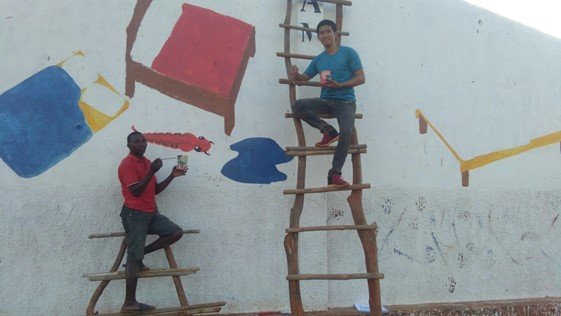 Peace Corps Volunteer Tatsumi Y. painting a mural in Mozambique.