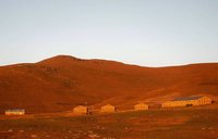 Small high school in the brown mountains with a blue sky.