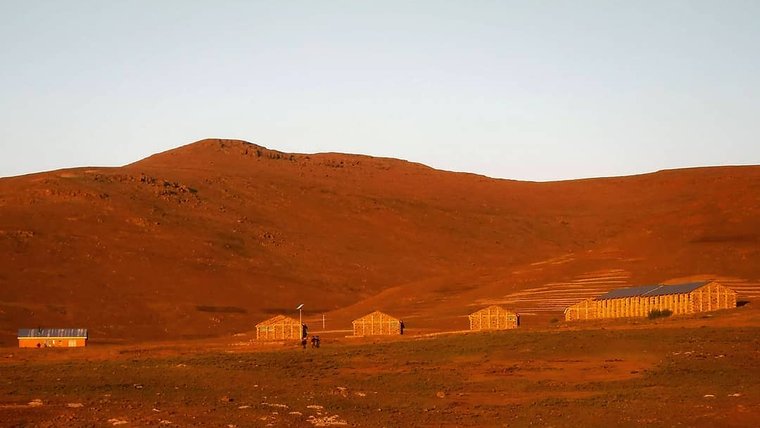 Small high school in the brown mountains with a blue sky.