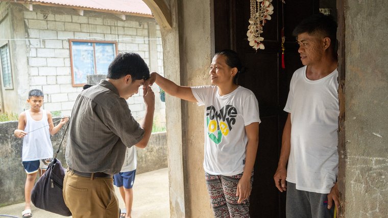 A Trainee greeting his host family with a ‘mano’ before entering their home.