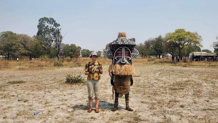Volunteer standing next to a local chief in Zambia.