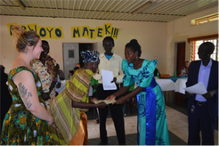 A homestay mother receives her certificate from the guest of honor as excited Lauren looks on