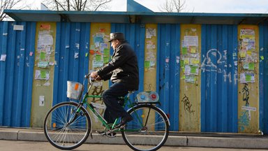 An older man rides a bike