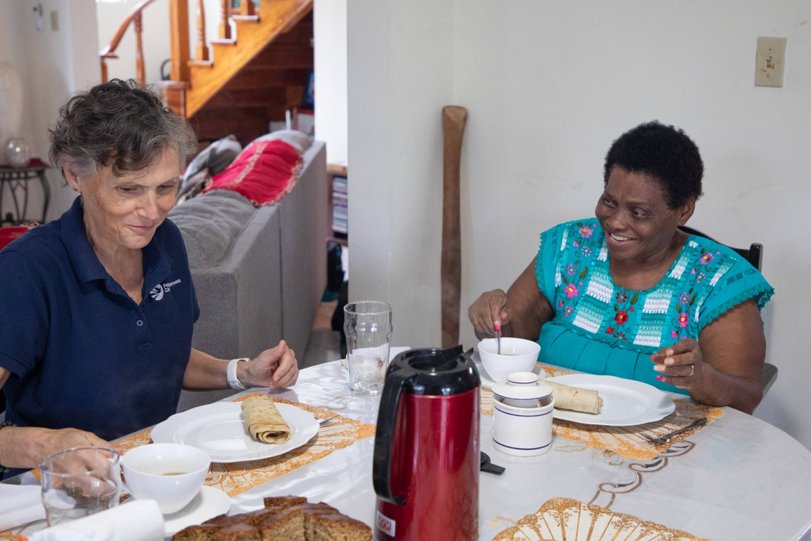 volunteer and host mother eating a meal at the table