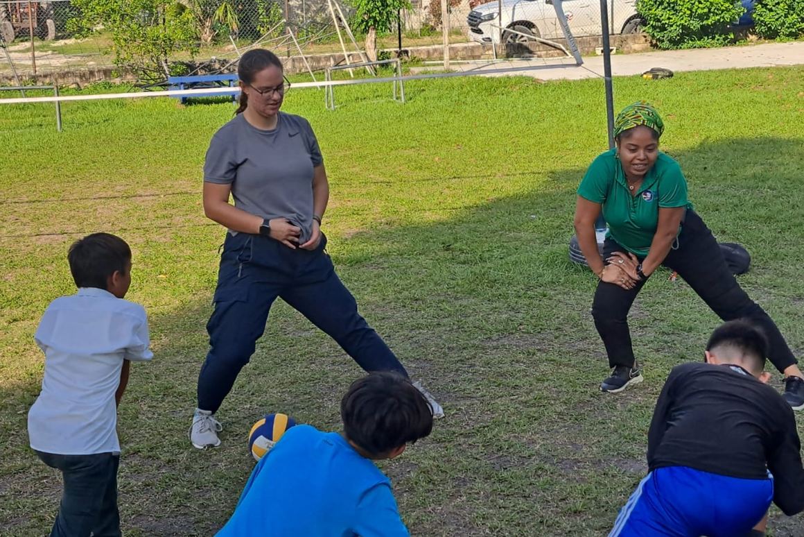 volunteer and program manager teaching pe class to boys
