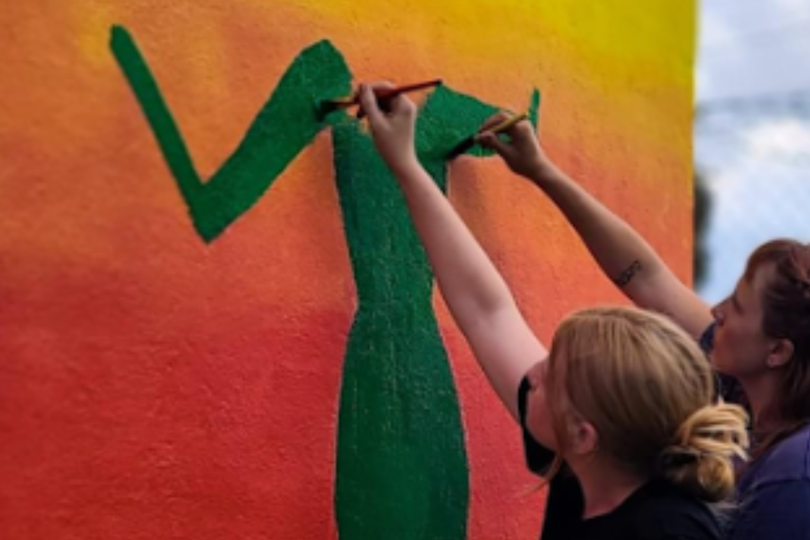 volunteers painting a mural