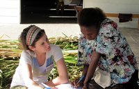A Volunteer and community health worker look over and discuss HIV action plans.