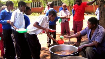 Serving vegatables to the students