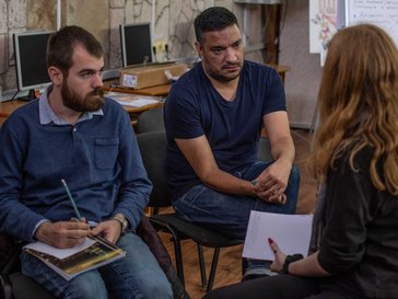Three people sitting down talking