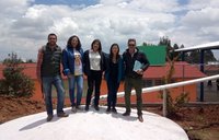 Volunteer Cassidy Pearson and collaborators pose on top of the 50,000 liter capacity water cistern.