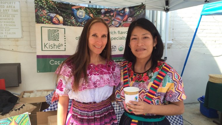 Wearing traditional Guatemalan outfits while serving coffee.