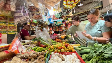 Trainees practicing the local language inside the market to buy cooking ingredients.