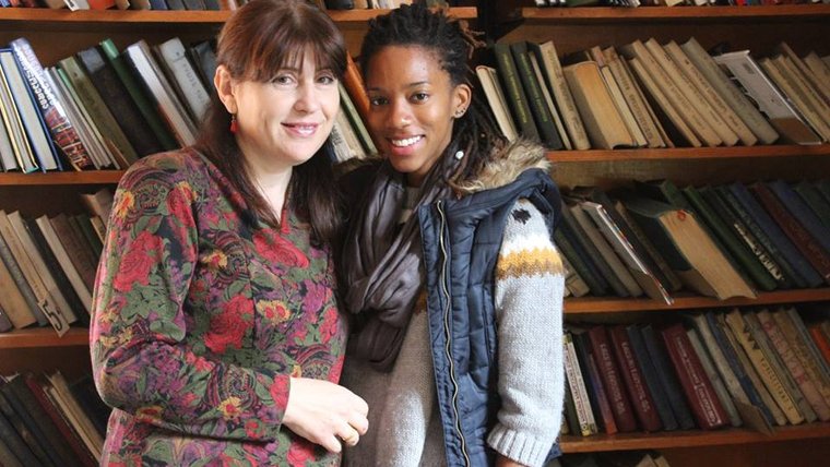 A woman from Georgia and a female Peace Corps Volunteer stand next to each other smiling.