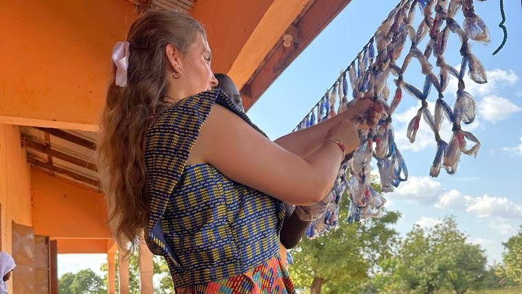 Rian works on a student project to create a volleyball net from recycled plastic bags.