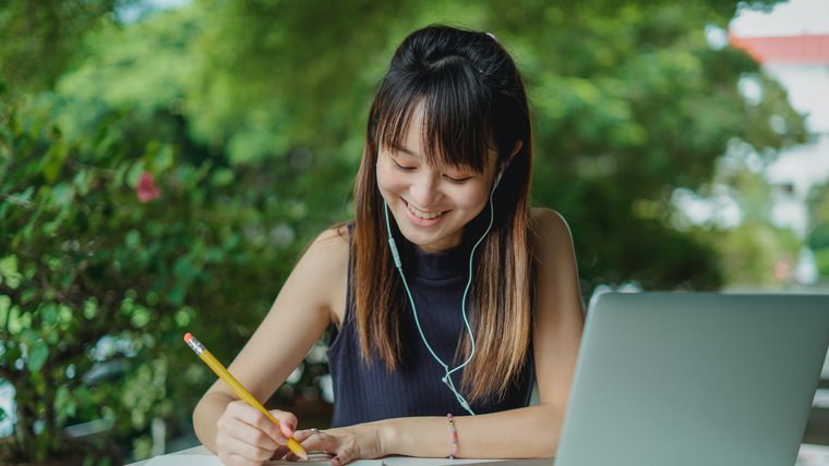 A woman writes at a desk