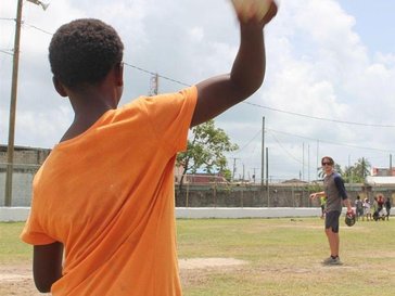 boy throwing baseball to volunteer