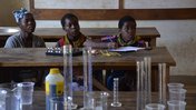 Three Malawian girls learn Chemistry at a STEM camp