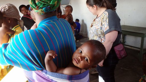 Waiting to be weighed at the outreach clinic, this baby stays warm despite the winter chill.