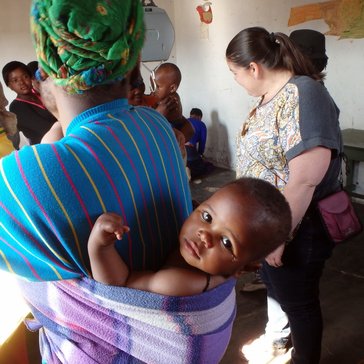 Waiting to be weighed at the outreach clinic, this baby stays warm despite the winter chill.