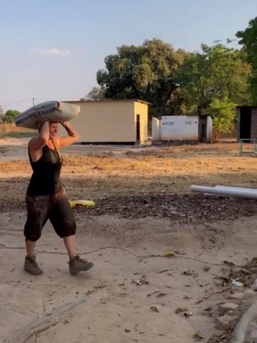Caelyn unloads bags of cement for an income-generation project in the community.