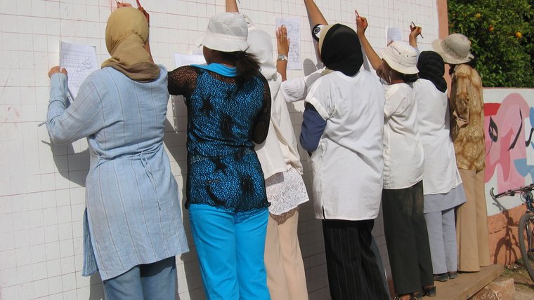 Moroccan girls sketch a mural with hygiene and sanitation awareness messages.
