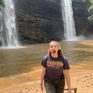 Deaf Volunteer Alana poses in front of a waterfall