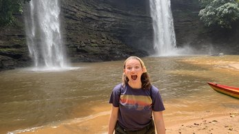 Deaf Volunteer Alana poses in front of a waterfall