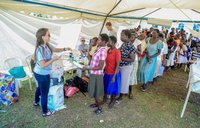 Volunteer Anna hands out bed nets to a line of Malawians.