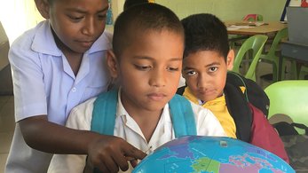 kids looking at a globe