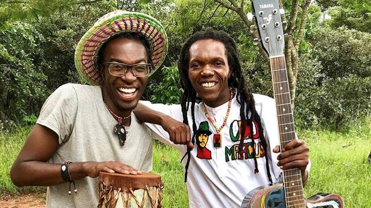 A black American male plays music with his friend from Tanzania