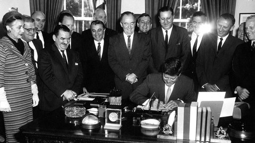 President Kennedy signing the Peace Corps Act as Hubert Humphrey (center) looks on. (Abbie Rowe, National Park Service)